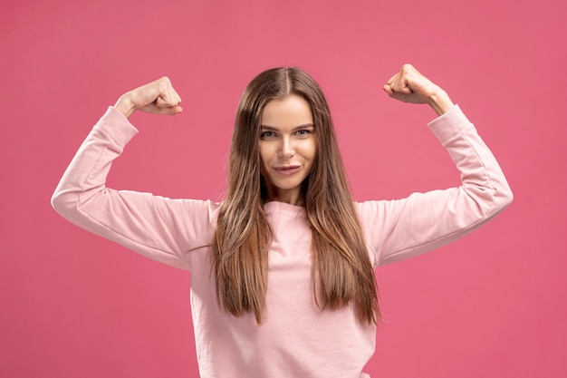 Vista frontal de una mujer fuerte flexionando sus bíceps