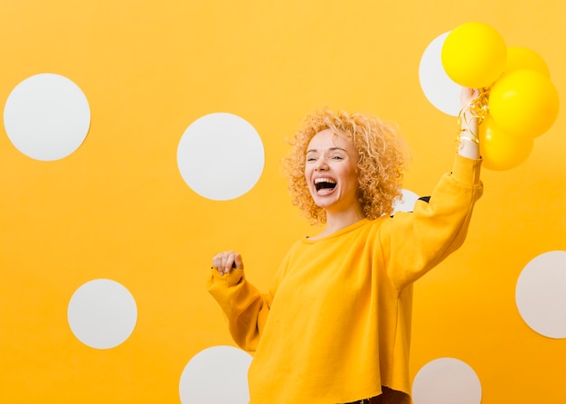 Foto gratuita vista frontal de mujer con globos amarillos