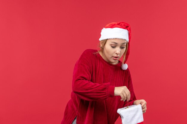 Vista frontal mujer joven abriendo gran calcetín de Navidad, vacaciones de Navidad rojo