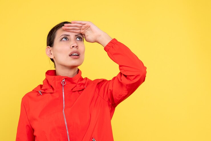 Foto gratuito vista frontal mujer joven en abrigo rojo sobre fondo amarillo