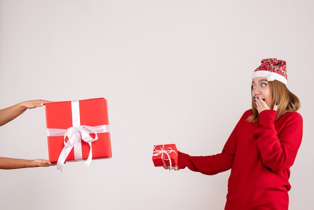 Vista frontal mujer joven aceptando otro regalo de Navidad de mujer