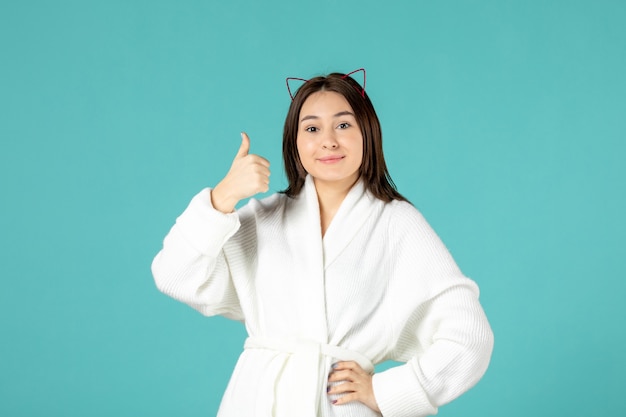 vista frontal, de, mujer joven, en, bata de baño, en, pared azul