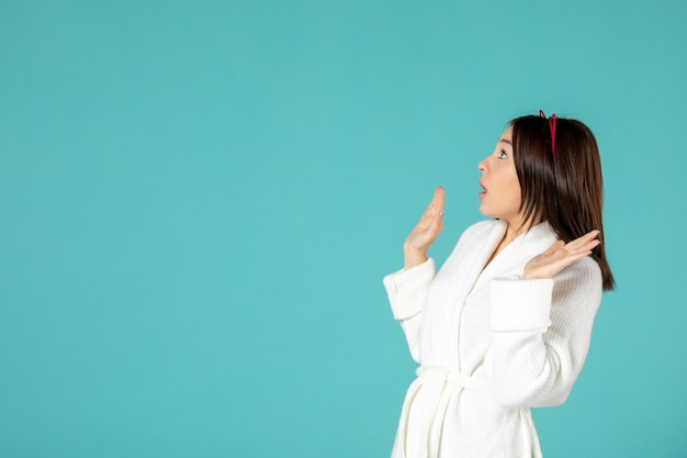 vista frontal, de, mujer joven, en, bata de baño, en, pared azul