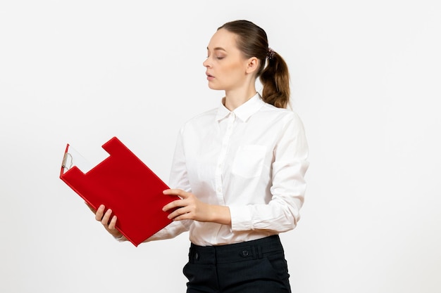 Vista frontal mujer joven en blusa blanca con archivo rojo sobre fondo blanco oficina emoción femenina sentimiento modelo trabajo