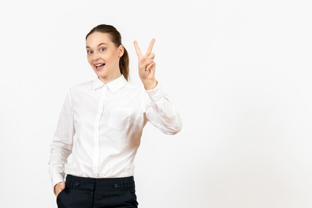 Vista frontal mujer joven en blusa blanca con cara emocionada sobre fondo blanco oficina de trabajo sentimiento femenino modelo emoción