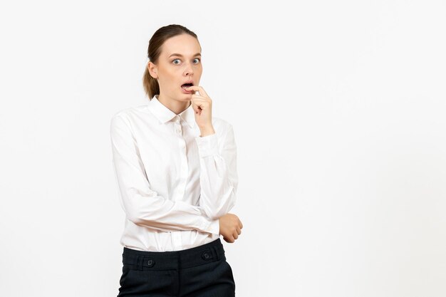 Vista frontal mujer joven en blusa blanca con cara nerviosa sobre fondo blanco trabajo de oficina emoción femenina modelo de sentimiento