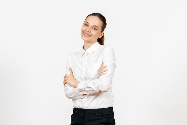 Vista frontal mujer joven en blusa blanca con cara sonriente sobre fondo blanco trabajo femenino sentimiento modelo oficina de emociones