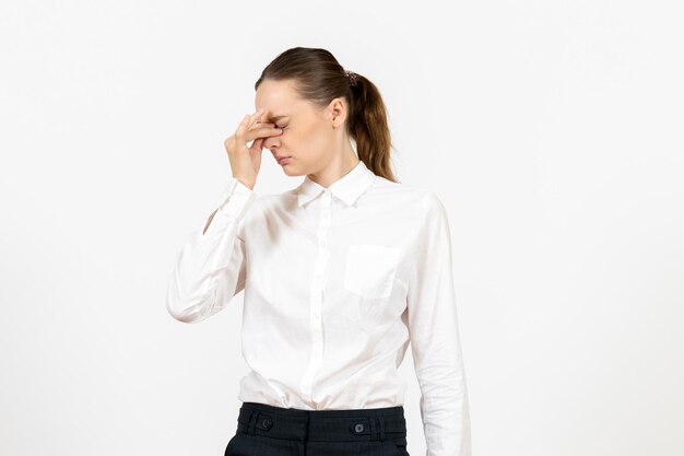 Vista frontal mujer joven en blusa blanca con dolor de cabeza sobre fondo blanco trabajo femenino sentimiento modelo emoción oficina