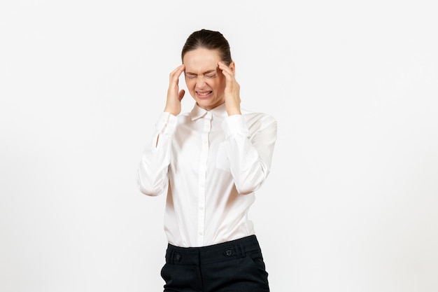 Vista frontal mujer joven en blusa blanca con dolor de cabeza sobre fondo blanco trabajo de oficina emoción femenina modelo de sentimiento