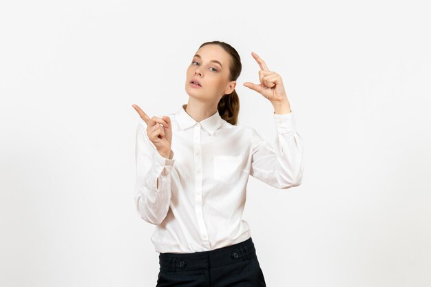 Vista frontal mujer joven en blusa blanca con expresión aburrida sobre fondo blanco oficina de trabajo sentimiento femenino modelo emoción