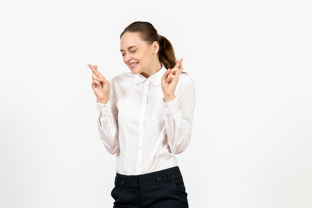 Vista frontal mujer joven en blusa blanca con expresión emocionada en el modelo de sentimiento de emoción femenina de trabajo de oficina de fondo blanco