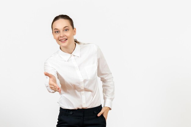 Vista frontal mujer joven en blusa blanca con expresión sonriente sobre fondo blanco oficina de trabajo sentimiento femenino modelo emoción
