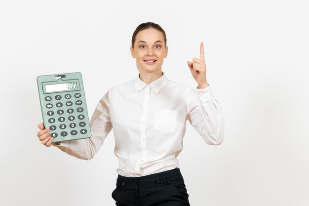 Foto gratuita vista frontal mujer joven en blusa blanca con gran calculadora sobre fondo blanco oficina trabajadora emoción sentimiento trabajo blanco