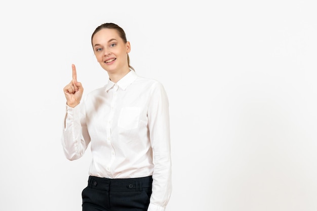 Vista frontal mujer joven en blusa blanca levantando su dedo sobre fondo blanco oficina de trabajo sentimiento femenino modelo emoción