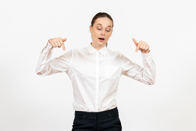 Vista frontal mujer joven en blusa blanca de pie sobre fondo blanco trabajo femenino sentimiento modelo emoción oficina