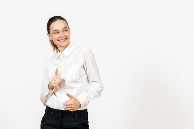 Vista frontal mujer joven en blusa blanca con rostro sonriente sobre fondo blanco trabajo femenino sentimiento modelo emoción oficina