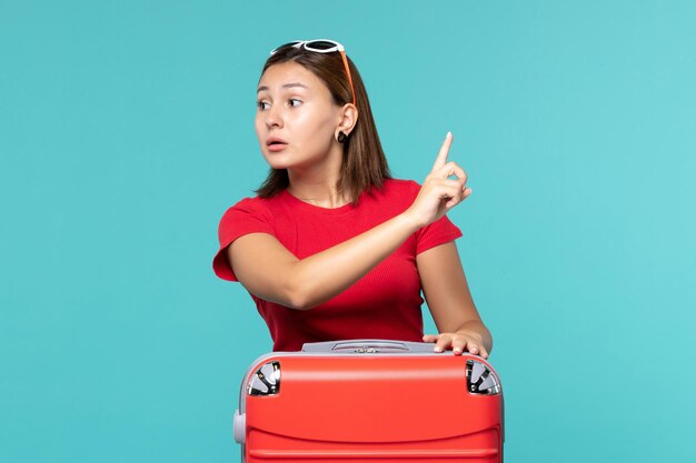 Vista frontal mujer joven con bolsa roja en el espacio azul