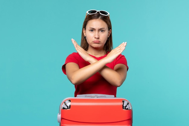 Foto gratuita vista frontal mujer joven con bolsa roja que muestra el signo de prohibición en el espacio azul