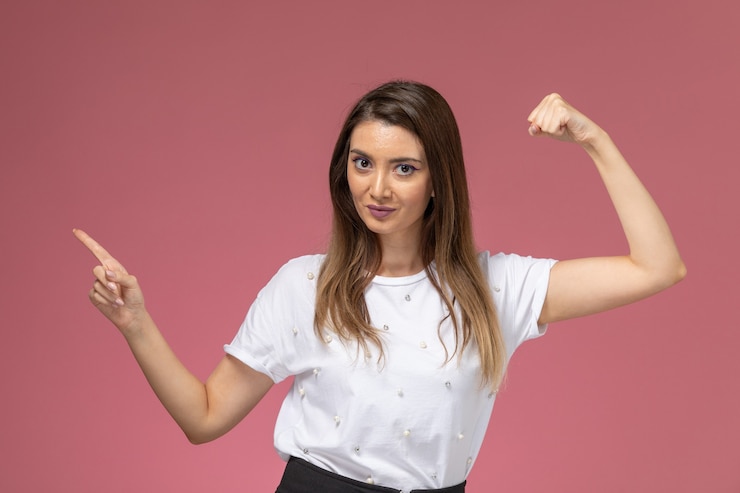 Foto gratuito vista frontal mujer joven en camisa blanca flexionando y posando, mujer de color modelo mujer