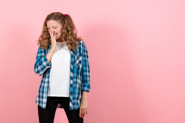 Vista frontal mujer joven en camisa a cuadros azul en la pared rosa emoción niña modelo moda joven niño