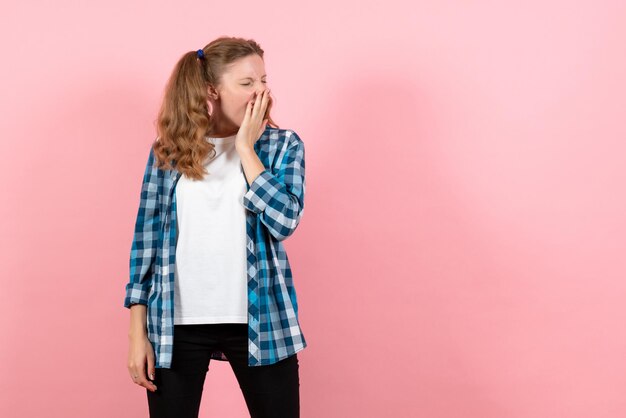 Vista frontal mujer joven en camisa a cuadros azul en la pared rosa emoción niña modelo moda joven niño