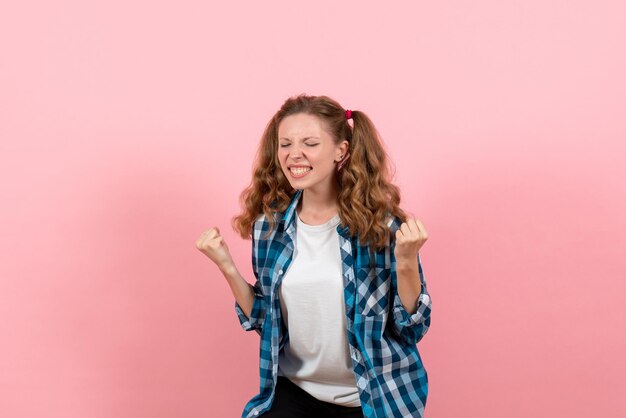 Vista frontal mujer joven en camisa a cuadros azul en la pared rosada joven emociones niña moda modelo de niño