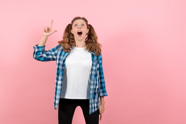 Foto gratuita vista frontal mujer joven en camisa a cuadros azul posando sobre fondo rosa mujer emociones modelo moda niña color