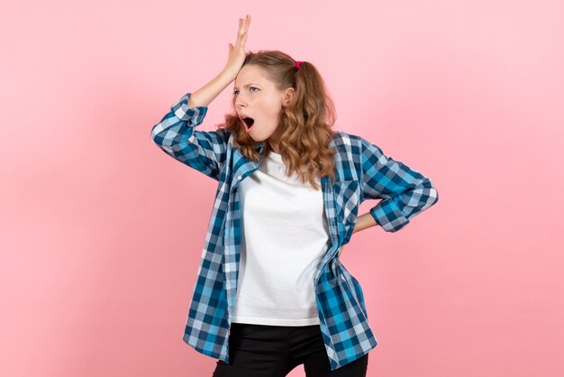 Vista frontal mujer joven en camisa a cuadros azul posando sobre fondo rosa mujer emociones modelo moda niñas color