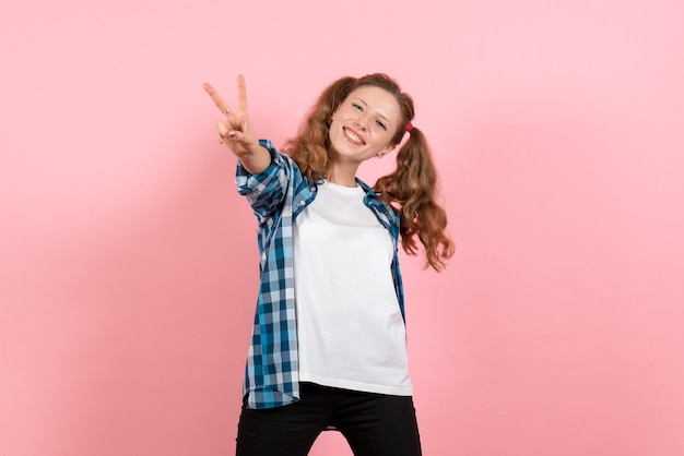 Vista frontal mujer joven en camisa a cuadros posando con expresión feliz sobre fondo rosa modelo mujer joven emociones color de niño