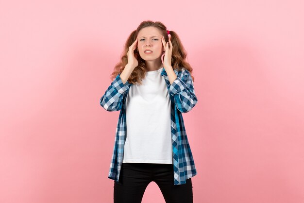 Vista frontal mujer joven en camisa a cuadros posando sobre fondo rosa modelo de emociones de color de mujer niño joven