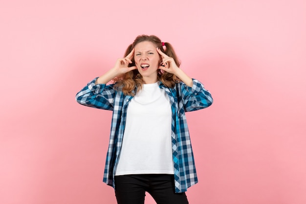 Vista frontal mujer joven en camisa a cuadros posando sobre un fondo rosa modelo juvenil emociones mujer niño niña