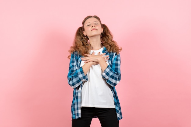 Vista frontal mujer joven en camisa a cuadros posando sobre fondo rosa modelo mujer emociones niño color juvenil