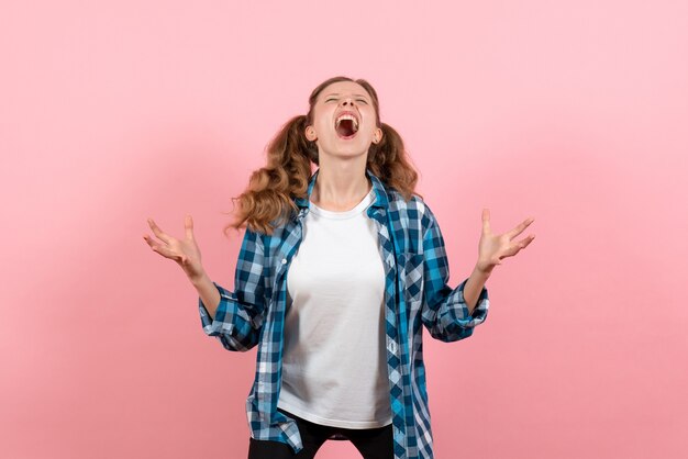 Vista frontal mujer joven en camisa a cuadros posando sobre fondo rosa modelo mujer joven emociones color de niño