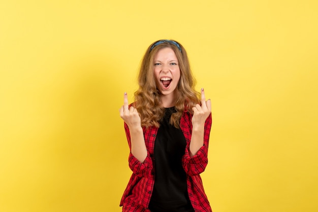 Vista frontal mujer joven en camisa a cuadros roja posando y gritando sobre fondo amarillo modelo de color humano mujer emoción