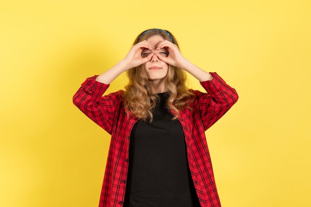 Foto gratuita vista frontal mujer joven en camisa a cuadros roja posando con los ojos cerrados sobre fondo amarillo modelo de color humano mujer emoción