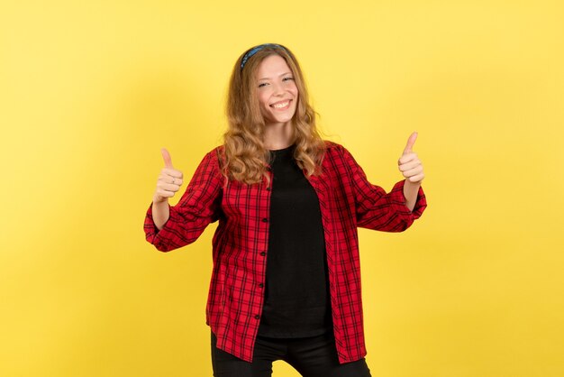 Vista frontal mujer joven en camisa a cuadros roja posando con sonrisa sobre fondo amarillo mujer emoción humana modelo moda chica