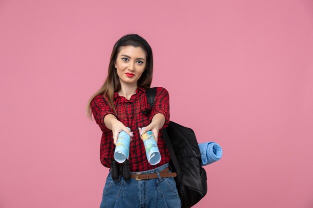 Vista frontal mujer joven en camisa roja con mapas en color rosa piso mujer humana