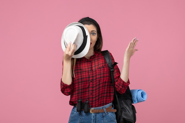 Vista frontal mujer joven en camisa roja con sombrero sobre fondo rosa color mujer modelo humano