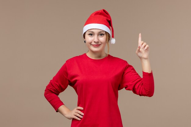 Vista frontal de la mujer joven con capa de navidad en marrón