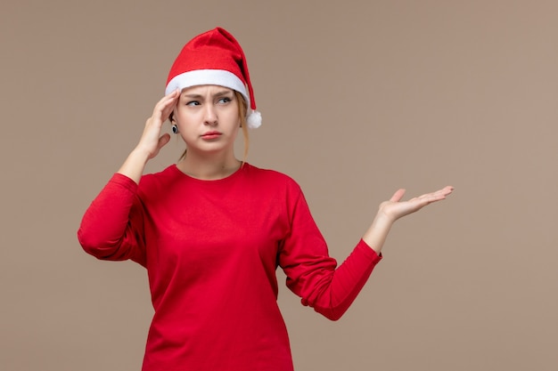 Vista frontal de la mujer joven con capa de navidad en marrón