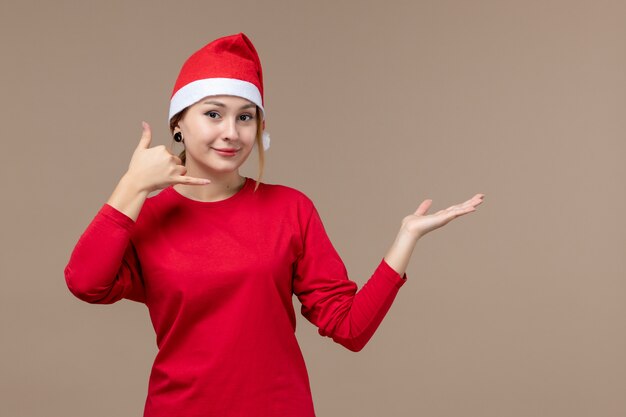 Vista frontal de la mujer joven con capa de navidad en marrón