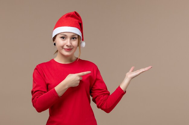 Vista frontal de la mujer joven con capa de navidad en marrón