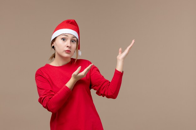 Vista frontal de la mujer joven con capa de navidad en marrón