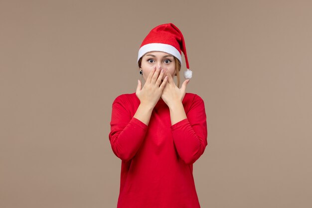 Vista frontal de la mujer joven con capa de navidad en marrón