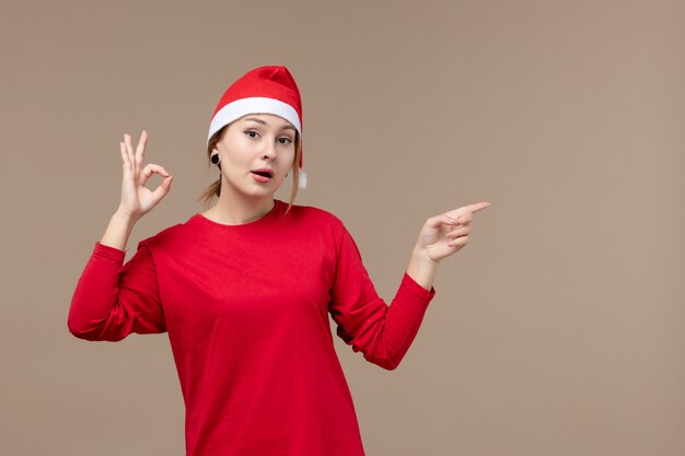 Vista frontal de la mujer joven con capa de navidad en marrón