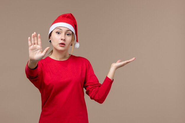 Vista frontal de la mujer joven con capa de navidad en marrón