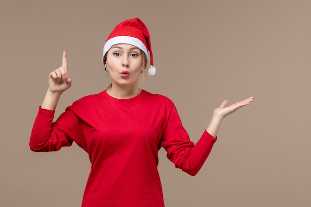 Vista frontal de la mujer joven con capa de navidad en el piso marrón emoción navidad rojo vacaciones