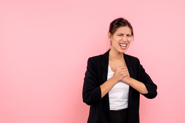 Foto gratuita vista frontal mujer joven en chaqueta oscura sobre fondo rosa