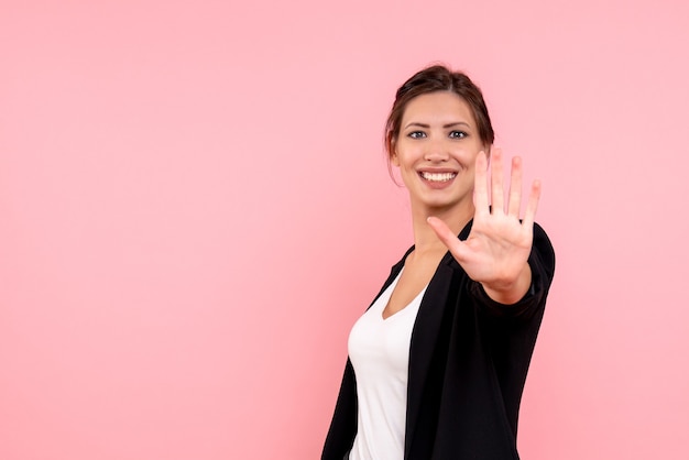 Foto gratuita vista frontal mujer joven en chaqueta oscura sobre fondo rosa