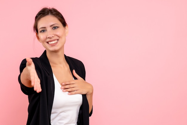 Foto gratuita vista frontal mujer joven en chaqueta oscura sobre fondo rosa